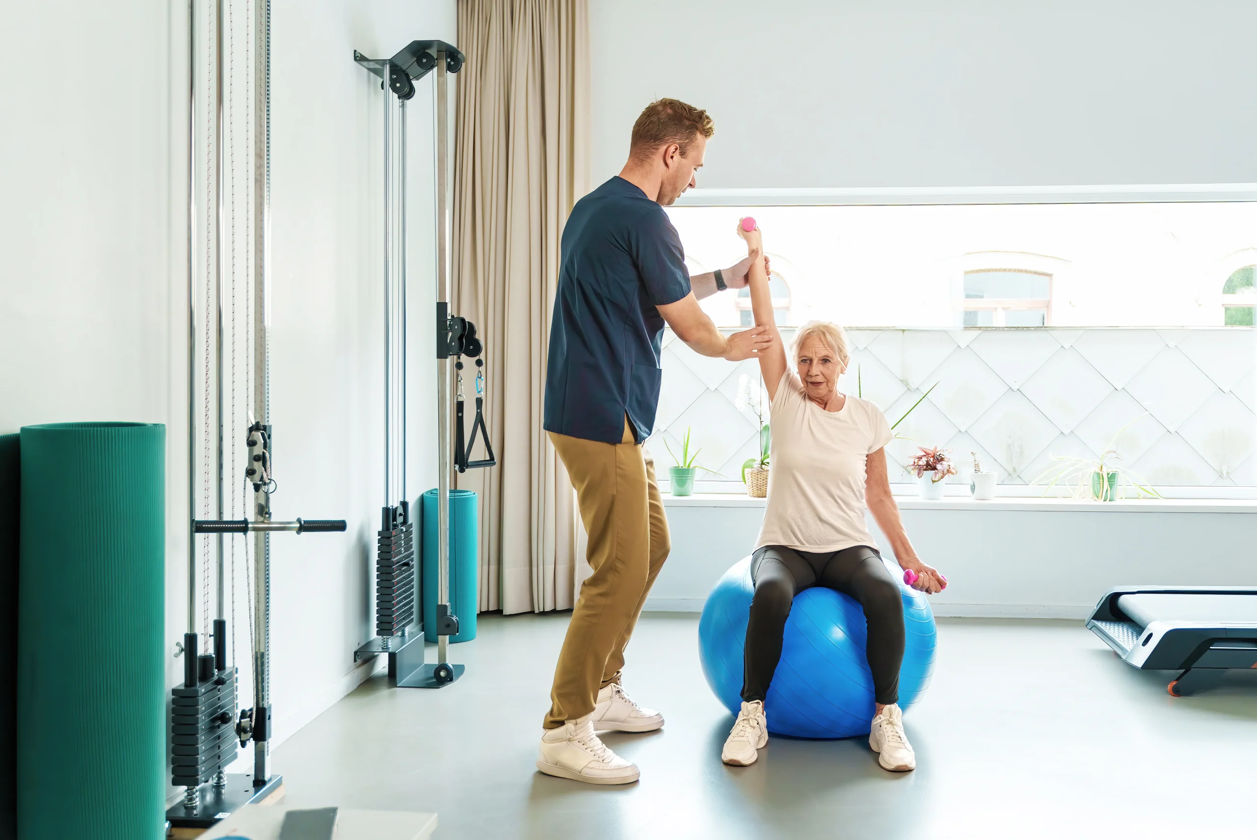 Physiotherapist assisting a woman with balance exercises during Gait and Balance Retraining Calgary