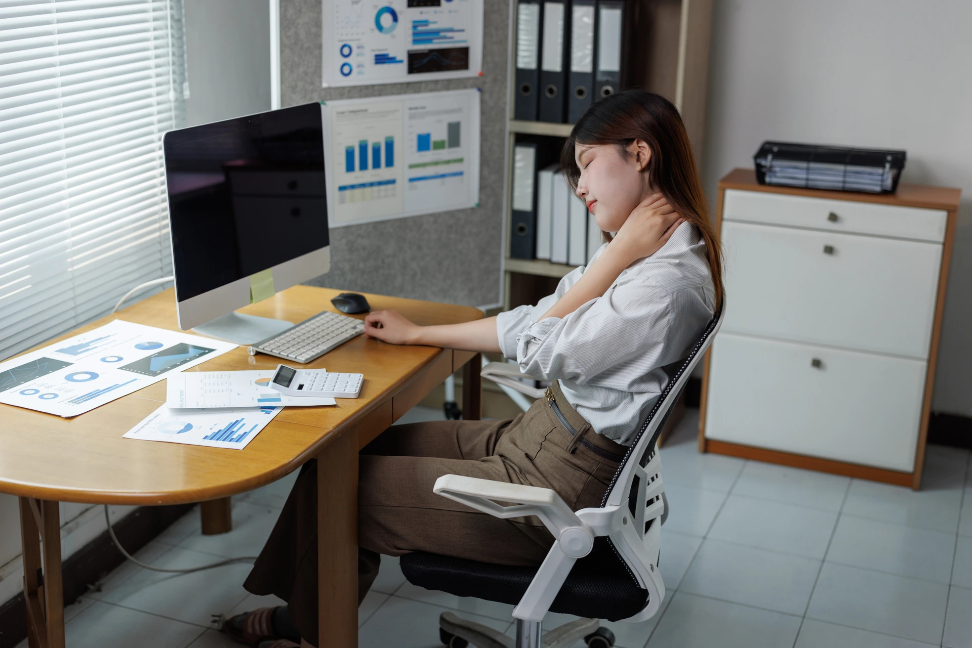 Work Ergonomics Calgary physiotherapist assessing workstation posture to improve comfort and reduce workplace strain